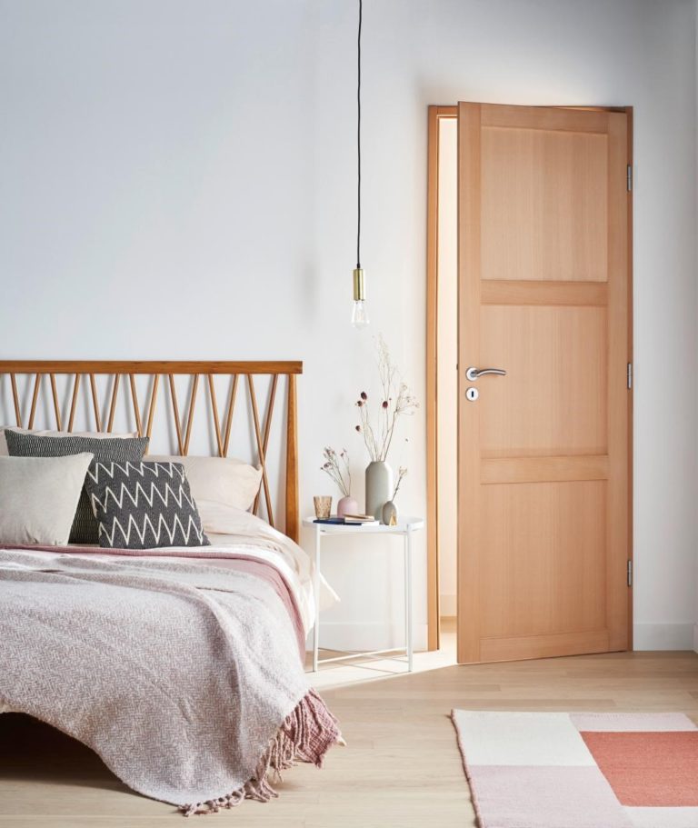 chambre parental avec lit en rotin et porte battante en bois