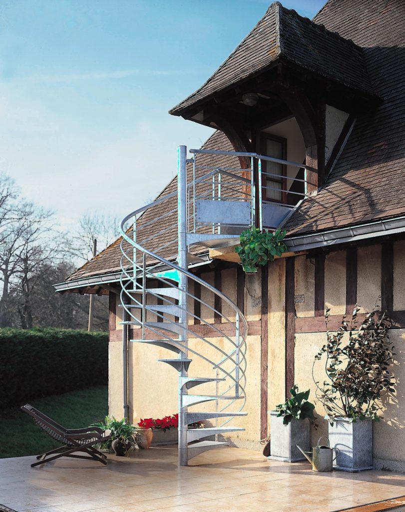 Maison ancienne avec poutre apparente. Escalier hélicoïdal qui par d'une porte fenêtre en bois.