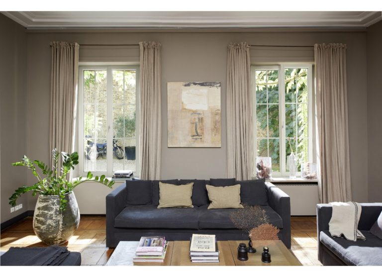 Grand salon avec 2 fenetres en PVC, canapé bleu, tables basse en bois