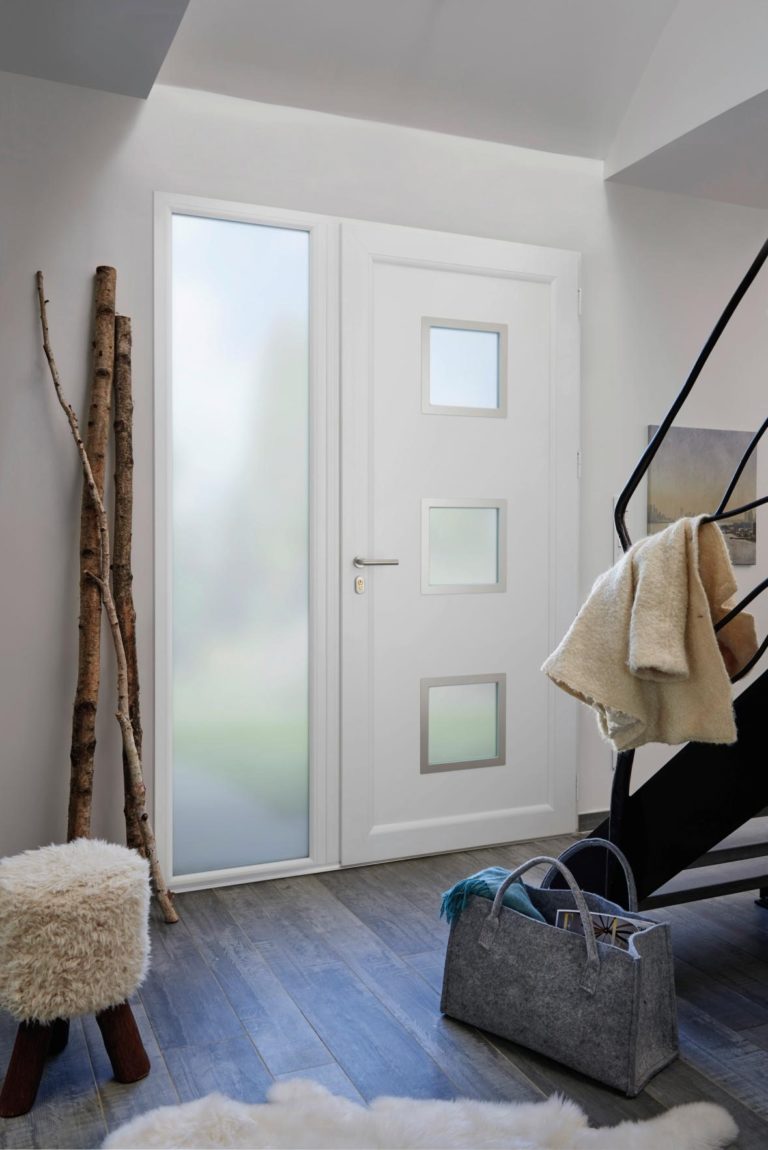Porte d'entrée PVC blanche en bas d'un escalier avec objet déco