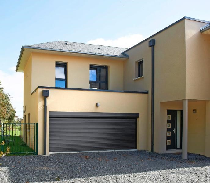 Porte de garage enroulable d'une maison aux tons beige