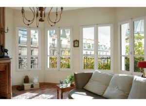 Grand salon en angle avec plusieurs fenêtres illuminant la pièce