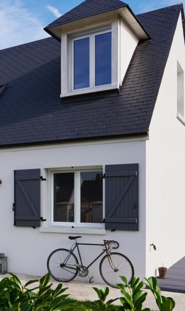 maison vue de l'extérieur avec des volets battants en PVC noir