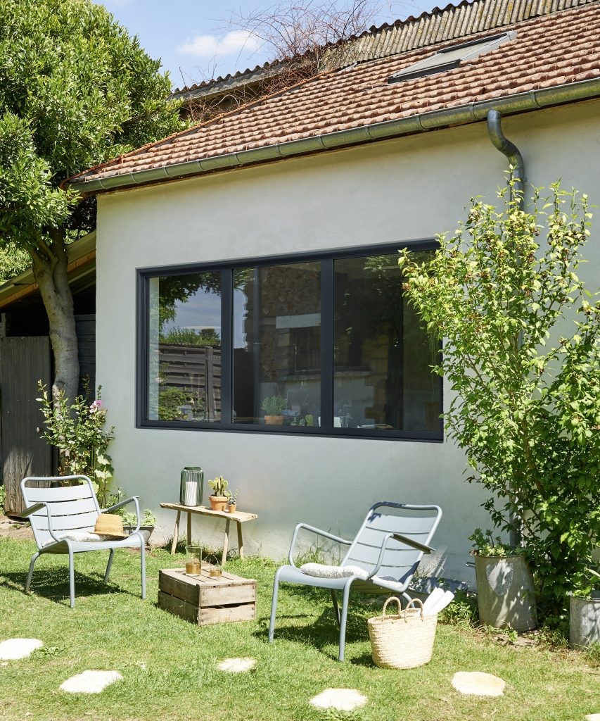 fenêtre sur mesure avec montant noir donnant sur un jardin
